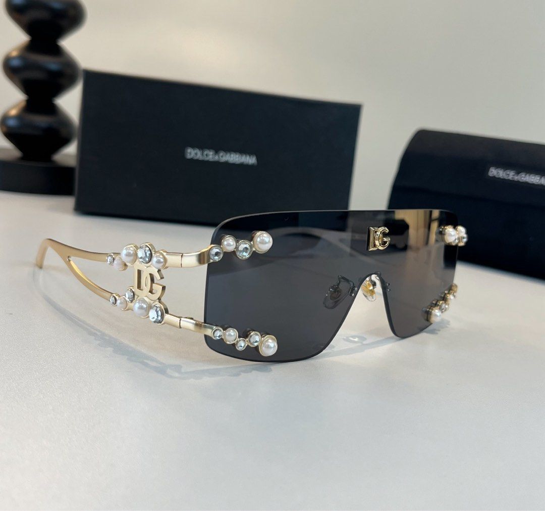 Dolce & Gabbana Sunglasses (Category: Sunglasses & Eyewear) located in Paranaque City. Submitted by kyriaki_thrift_shop (Listing ID 1467403216, Image 1). Description: - Brand: Dolce & Gabbana - Style: Oversized shield sunglasses with dark lenses - Details: Gold-tone metal arms accented with pearls and clear crystals, featuring the iconic DG logo on the temples and top lens corner - Condition: Brand new, never worn out, stored clean - Inclusions: 