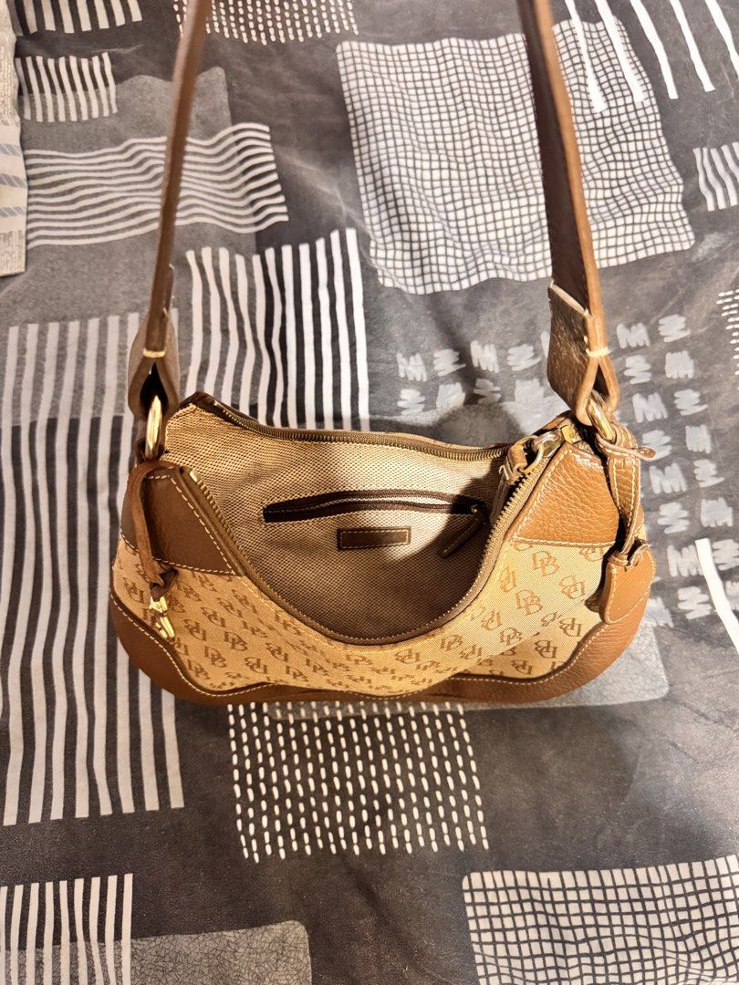 Dooney & Bourke Monogram Shoulder Bag Brown (Category: Luxury Bags & Wallets) located in Manila. Submitted by champagnemam1 (Listing ID 1467443214, Image 2). Description: - Brand: Dooney & Bourke - Material: Brown canvas monogram with tan leather trim and white stitching - Hardware: Gold-tone - Closure: Top zip closure - Interior: Fabric lining with a convenient zipper pocket - Strap: Single leather strap - Style: Classic structured shape, ideal 