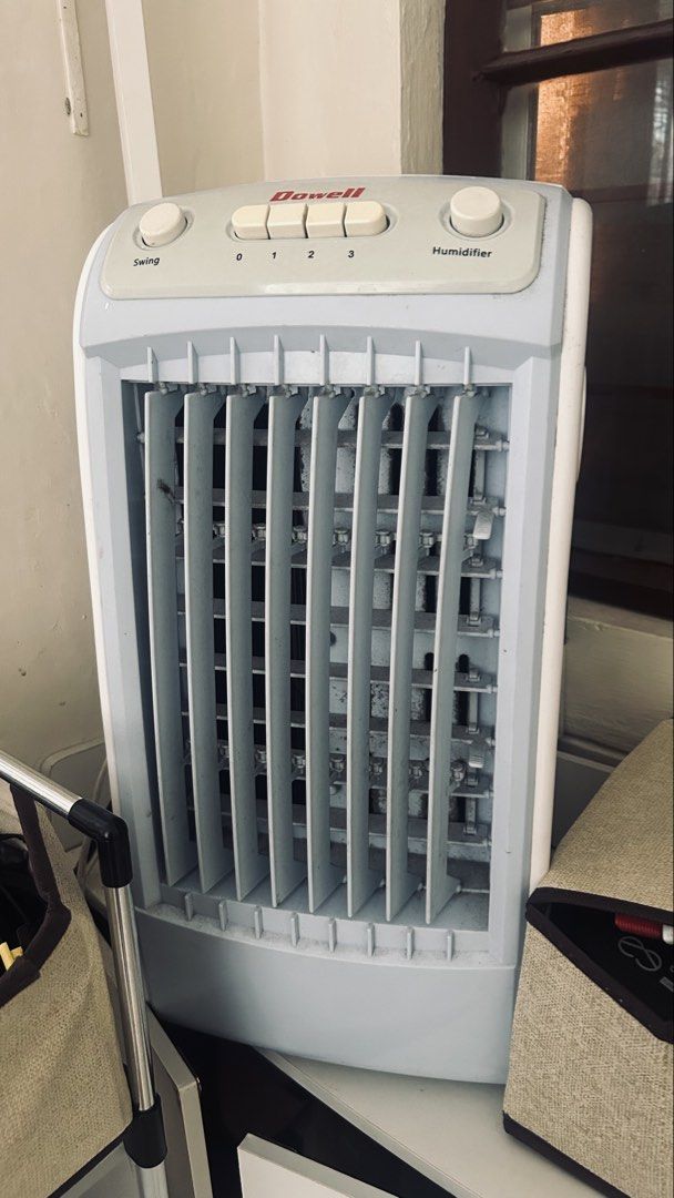 Dowell Air Cooler (Category: Fans) located in General Trias. Submitted by csrtechsol61982 (Listing ID 1467381908, Image 1). Description: - Brand/Model: Dowell Tower Fan with built-in humidifier - Color: Light grey and white plastic body - Settings: 3 speed levels (0 to 3), swing button, and humidifier dial - Condition: Dusty on the front grilles and louvers; needs thorough cleaning before use - Usage: Ideal standard size for tabletop or floor sta