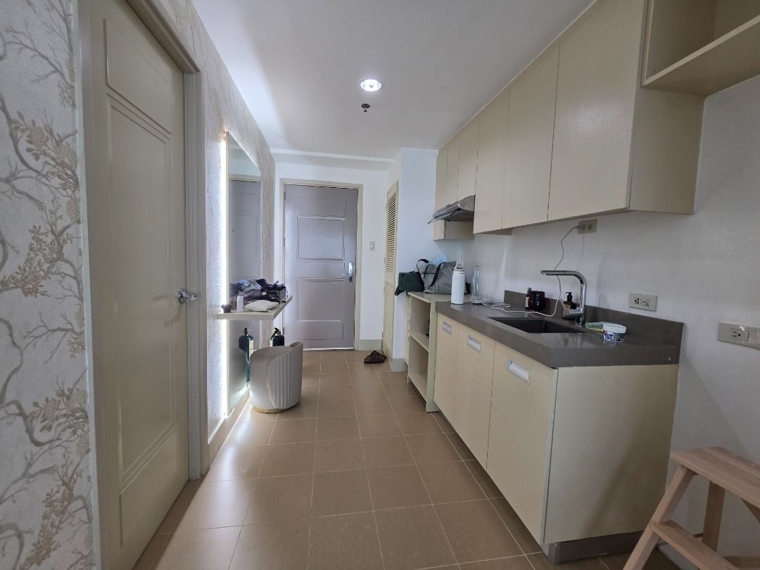 Edades Tower Rockwell Studio for Rent (Category: Apartments & Condos) located in Quezon City. Submitted by wkendfinds (Listing ID 1467446626, Image 2). Description: - Fully furnished studio unit, ready for immediate move-in - Sleeping & Living: Queen-size bed, plush armchair, study desk, and vanity mirror table - Kitchen: Built-in cabinets, sink, and stacked washer-dryer in a dedicated laundry closet - Bathroom: Glass shower enclosure with a luxu