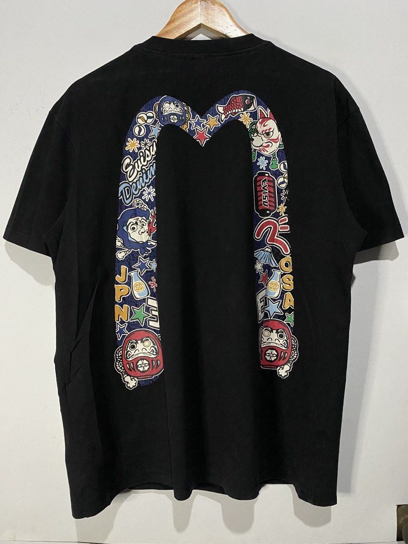 EVISU TSHIRT (Category: Tshirts & Polo Shirts ) located in Jaen. Submitted by oshimamark58418 (Listing ID 1467547549, Image 1). Description: - Brand: EVISU - Color: Black - Size: L (Width: 22 inches, Length: 27 inches) - Design: Eye-catching Japanese-inspired graphic print on the back, subtle chest embroidery, and custom woven tags at the hem - Condition: Excellent pre-owned condition, perfect for casual wear and streetwear styling.