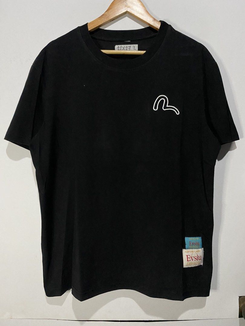 EVISU TSHIRT (Category: Tshirts & Polo Shirts ) located in Jaen. Submitted by oshimamark58418 (Listing ID 1467547549, Image 3). Description: - Brand: EVISU - Color: Black - Size: L (Width: 22 inches, Length: 27 inches) - Design: Eye-catching Japanese-inspired graphic print on the back, subtle chest embroidery, and custom woven tags at the hem - Condition: Excellent pre-owned condition, perfect for casual wear and streetwear styling.