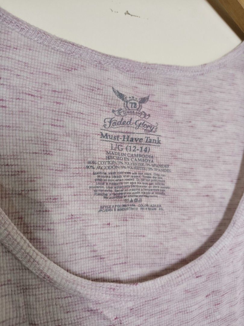 ORIGINAL FADED GLORY TANK TOP (Category: Sleeveless) located in Morong. Submitted by katiesmodernthrift (Listing ID 1467370722, Image 3). Description: Faded Glory "Must Have Tank" (size L/G) based on the tag visible in the collar area. Key Visual Details Color: Light pink / mauve marl or heather knit fabric with subtle white speckling. Design: Scoop-neck sleeveless tank top with standard shoulder straps and a relaxed fit. Brand/Label: Faded Glory