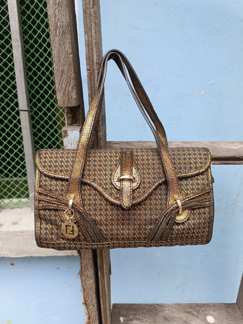 Fendi metallic gold patterned shoulder handbag (Category: Luxury Bags & Wallets) located in Manila. Submitted by alwaysgoodzthrift (Listing ID 1467416377, Image 1). Description: - Brand: Fendi - Color/Pattern: Dark brown fabric with a stunning metallic gold diamond pattern - Straps: Double straps in a unique crackled gold leather texture - Closure: Front flap with a secure metal clasp - Hardware/Accents: Includes a signature hanging metal Fendi l