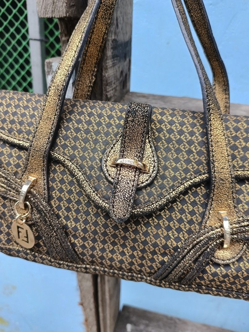 Fendi metallic gold patterned shoulder handbag (Category: Luxury Bags & Wallets) located in Manila. Submitted by alwaysgoodzthrift (Listing ID 1467416377, Image 3). Description: - Brand: Fendi - Color/Pattern: Dark brown fabric with a stunning metallic gold diamond pattern - Straps: Double straps in a unique crackled gold leather texture - Closure: Front flap with a secure metal clasp - Hardware/Accents: Includes a signature hanging metal Fendi l