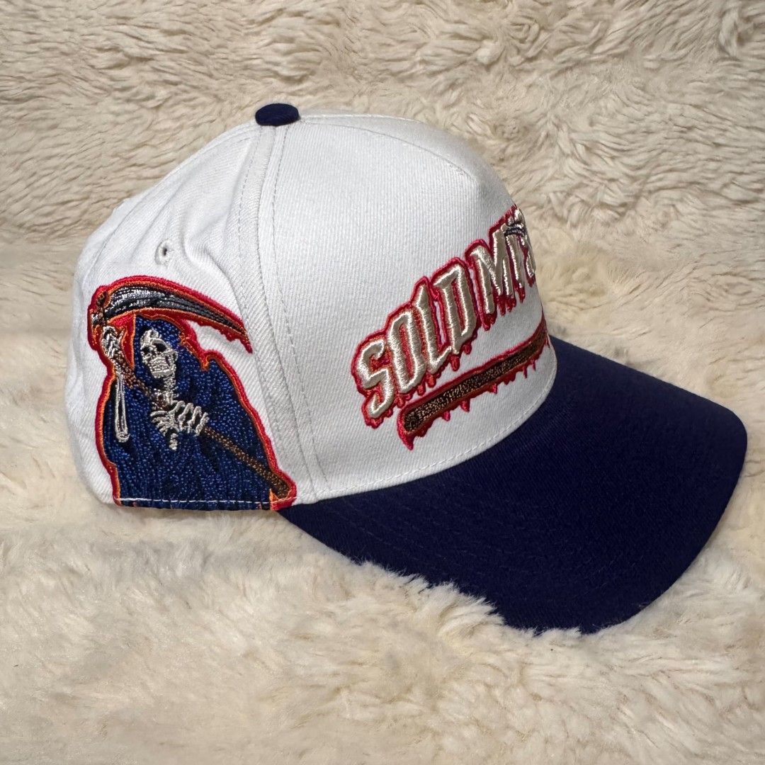 Field Grade Sold My Soul Snapback Hat (Category: Caps & Hats) located in Manila. Submitted by westcity.mnl (Listing ID 1467510070, Image 1). Description: - Brand: Field Grade - Style: Snapback cap (White & Navy Blue) - Design: Large 'Sold My Soul' embroidery with grim reaper graphics - Fit: Adjustable plastic strap closure - Details: Branded interior taped seams, clean panels, and crisp stitching - Condition: Solid structure overall.