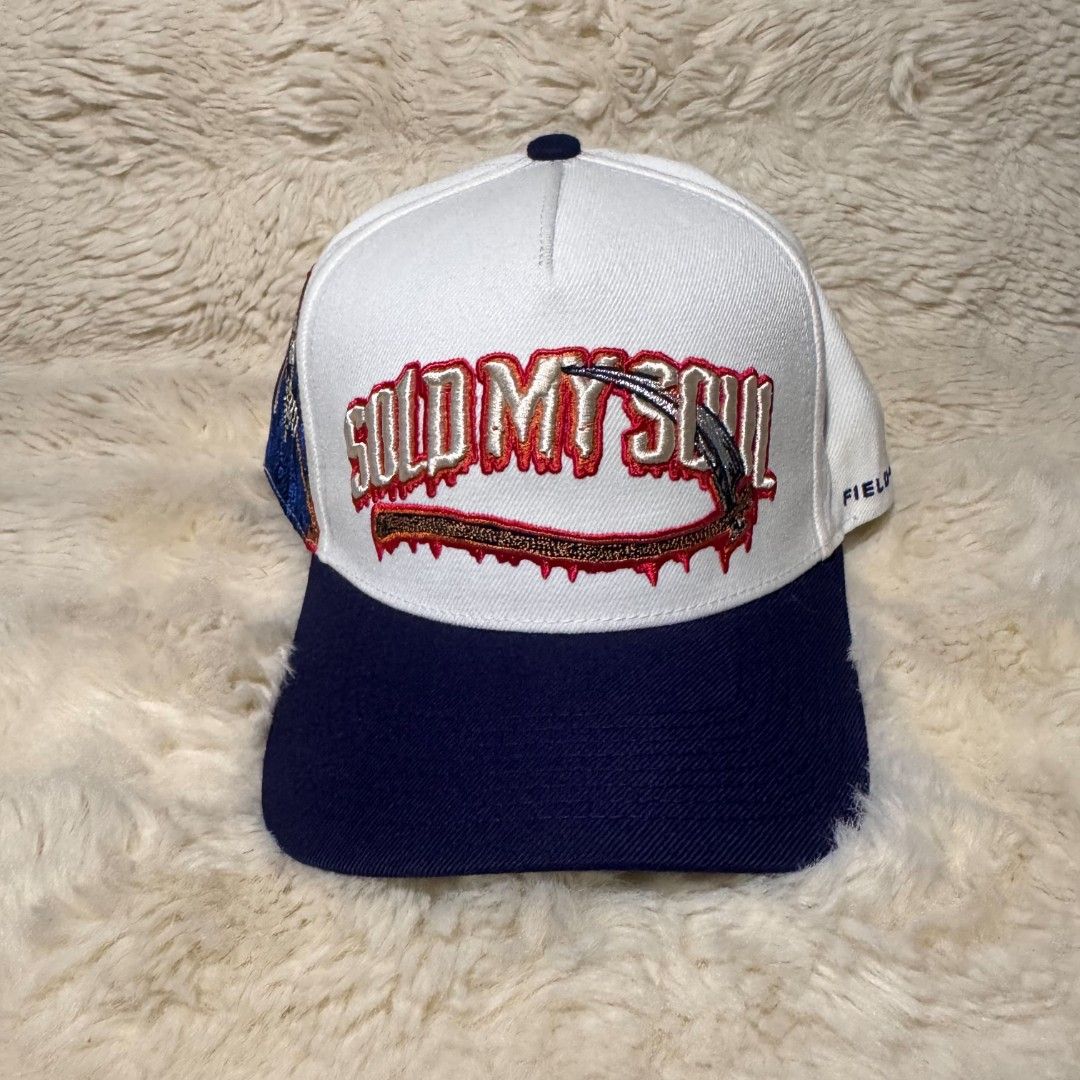 Field Grade Sold My Soul Snapback Hat (Category: Caps & Hats) located in Manila. Submitted by westcity.mnl (Listing ID 1467510070, Image 2). Description: - Brand: Field Grade - Style: Snapback cap (White & Navy Blue) - Design: Large 'Sold My Soul' embroidery with grim reaper graphics - Fit: Adjustable plastic strap closure - Details: Branded interior taped seams, clean panels, and crisp stitching - Condition: Solid structure overall.