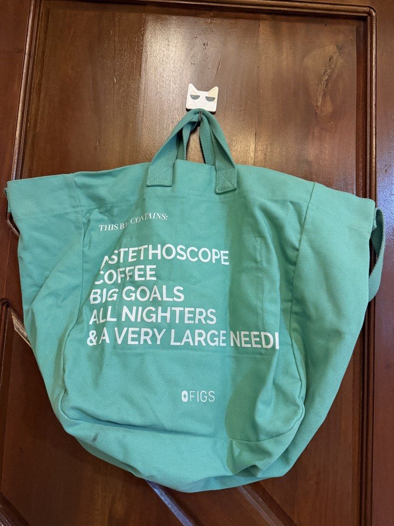 FIGS Green Canvas Work Tote Bag (Category: Tote Bags) located in Mandaluyong City. Submitted by riz_040521 (Listing ID 1467472833, Image 1). Description: - Brand: FIGS - Material: Durable green canvas - Design: Front text lists everyday medical gear essentials - Straps: Dual top handles plus a convenient shoulder strap - Interior: Roomy compartment with key ring clips - Special Feature: Custom ID label patch with blank lines for name, pronouns, a