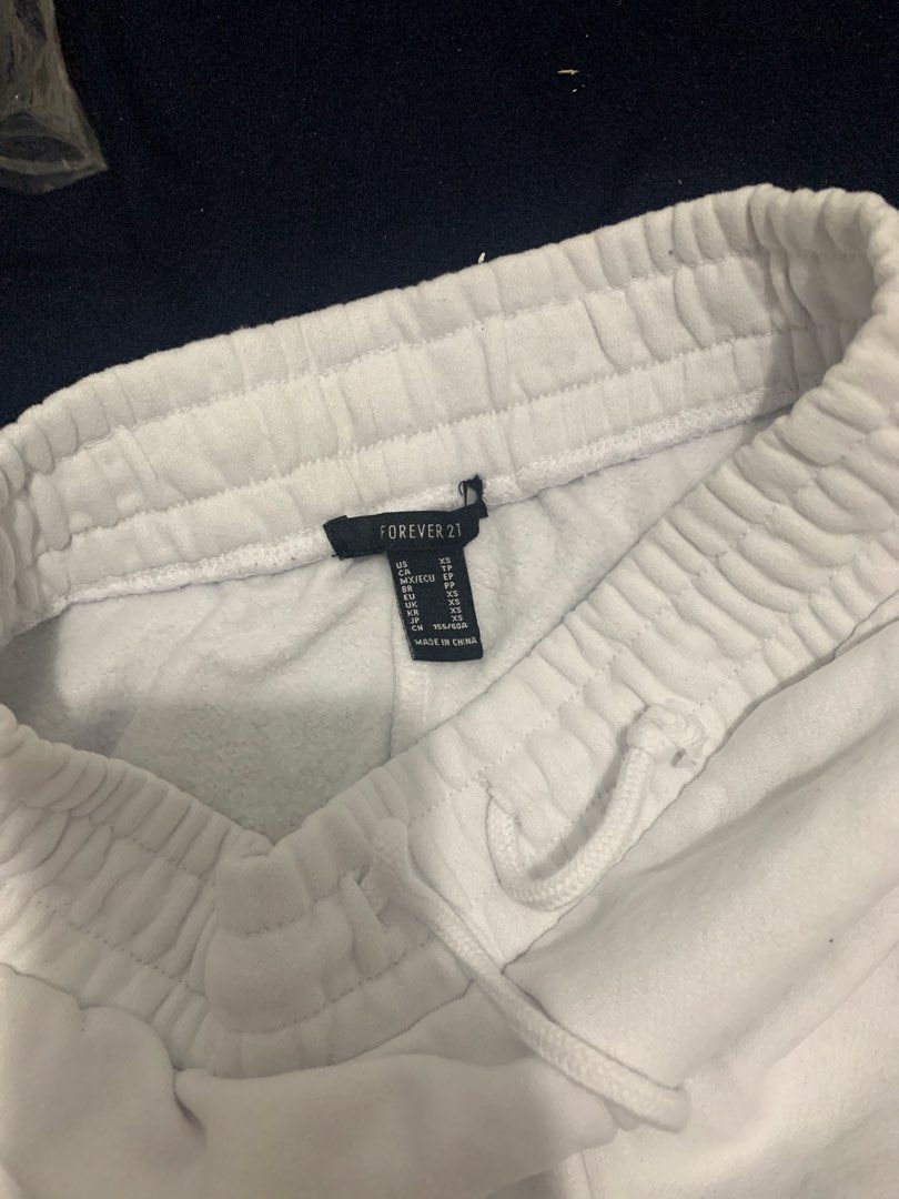 Forever 21 White Fighter Sweatpants Size XS (Category: Activewear) located in Manila. Submitted by closetsunday (Listing ID 1467468018, Image 3). Description: White sweatpants by Forever 21 in size XS. Pink embroidered word 'FIGHTER' runs down the leg. Elastic waistband with a drawstring for adjustment. Elastic cuffs at the ankles. Soft fleece material inside. Clean fabric with clear stitching..