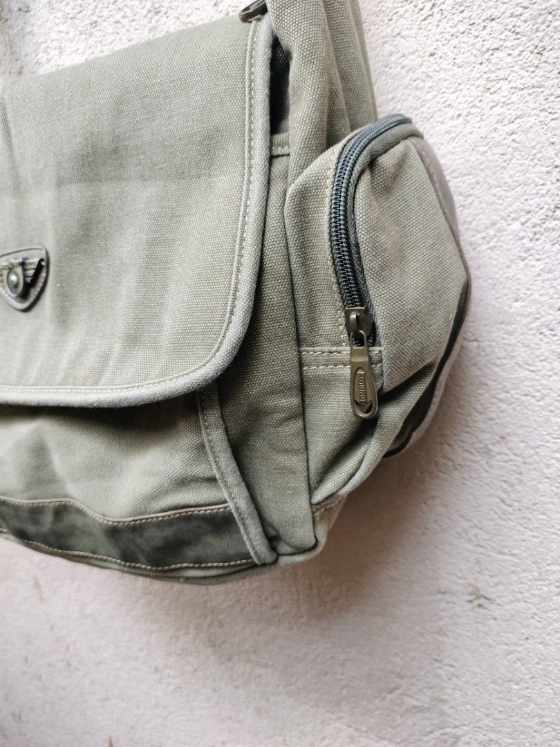 Fossil Canvas Messenger Bag Khaki Green (Category: Sling Bags) located in General Santos City (Dadiangas). Submitted by sinister_thrifts (Listing ID 1467569746, Image 3). Description: - Khaki green canvas messenger bag - Flap closure with buckle detail - Two zippered side pockets - Adjustable strap - Minor signs of wear on strap and leather accents - Ideal for everyday use.