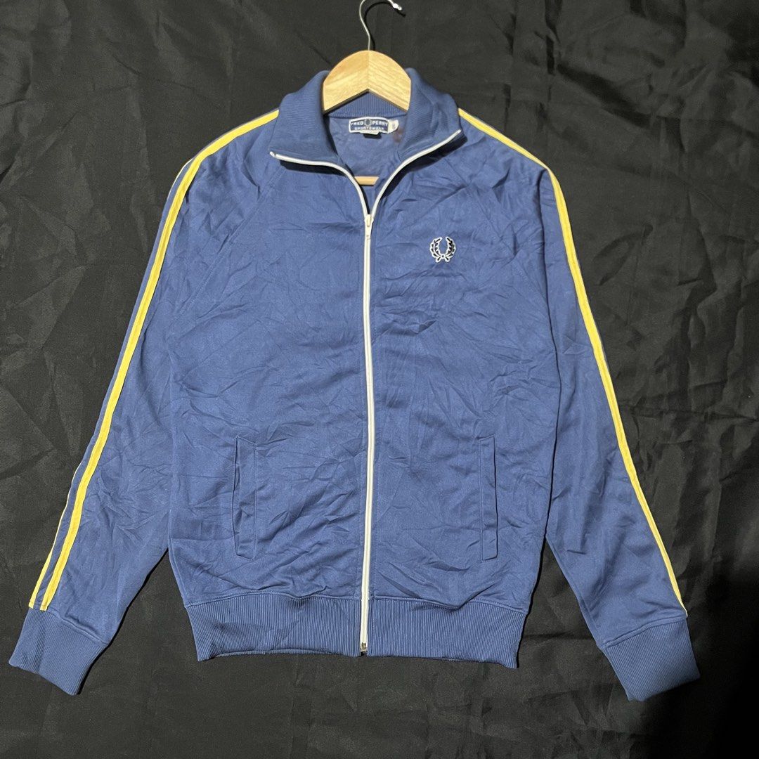 Fred Perry Track Jacket Blue Yellow Zip Up (Category: Coats, Jackets and Outerwear) located in Manila. Submitted by giormagne (Listing ID 1467472048, Image 1). Description: - Authentic blue Fred Perry track jacket with vintage sportswear vibe - Eye-catching yellow stripes down both sleeves - Full white zipper closure and matching white piping on the high collar - Signature embroidered laurel wreath logo on the left chest - Equipped with two funct