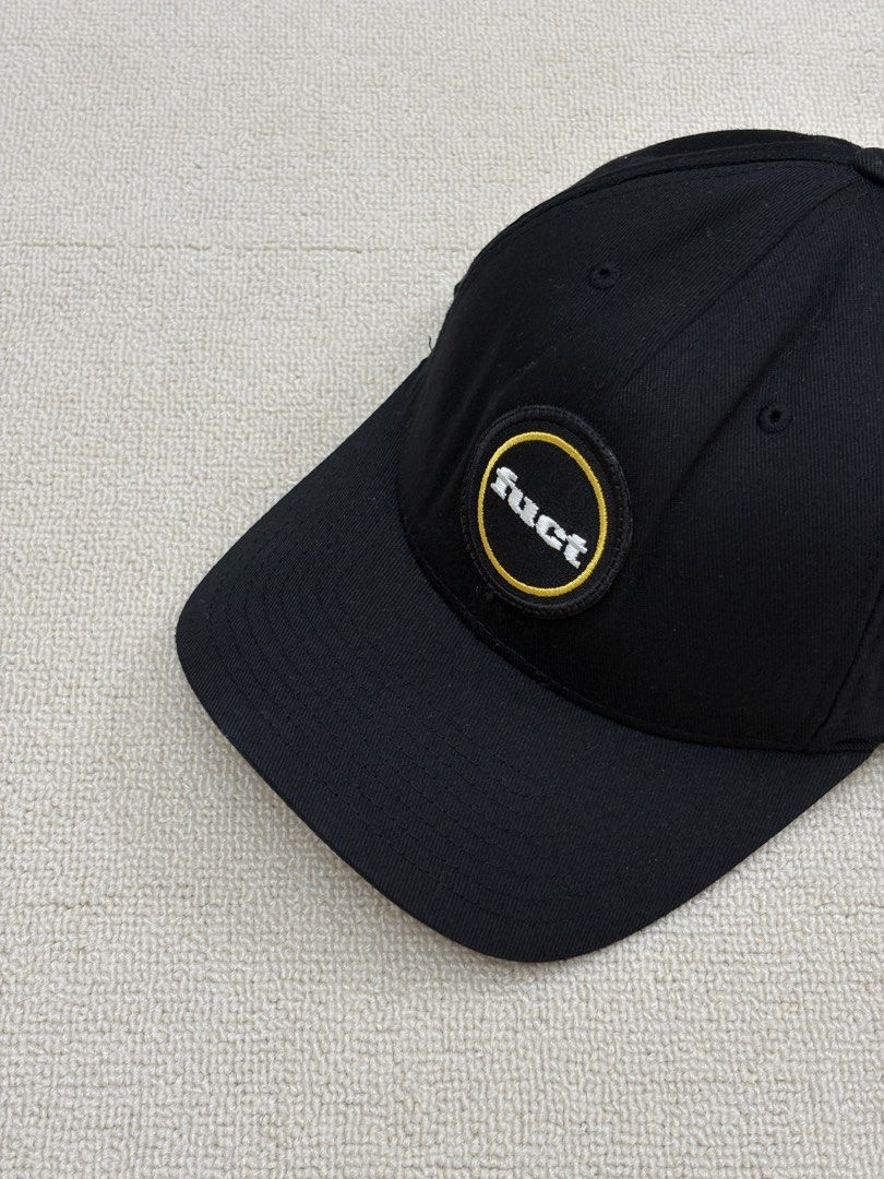 FUCT Patch Flexfit Cap (Category: Caps & Hats) located in Manila. Submitted by porma.market (Listing ID 1467403999, Image 1). Description: - Brand: FUCT (EST 1991 Los Angeles CA) - Color: Black with white and yellow embroidered logo patch - Material: 80% acrylic, 20% wool blend - Fit: Original Flexfit elastic band for comfortable wear - Design: Classic curved brim with stylish grey underbrim - Condition: Clean structure all around, ready to wear.