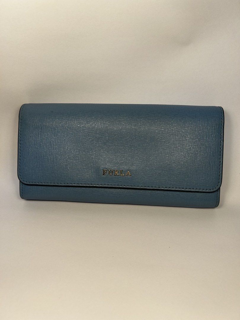 Furla Blue Leather Long Wallet (Category: Wallets & Card holders) located in Rizal. Submitted by bebangel (Listing ID 1467487610, Image 1). Description: - Brand: Furla - Material: Blue textured leather with matching blue interior lining - Hardware: Gold-tone snap button closure - Condition: Clean exterior structure; includes minor pen ink marks on the interior flap near the snap (highlighted in photos) - Features: Embossed Furla logo branding nea