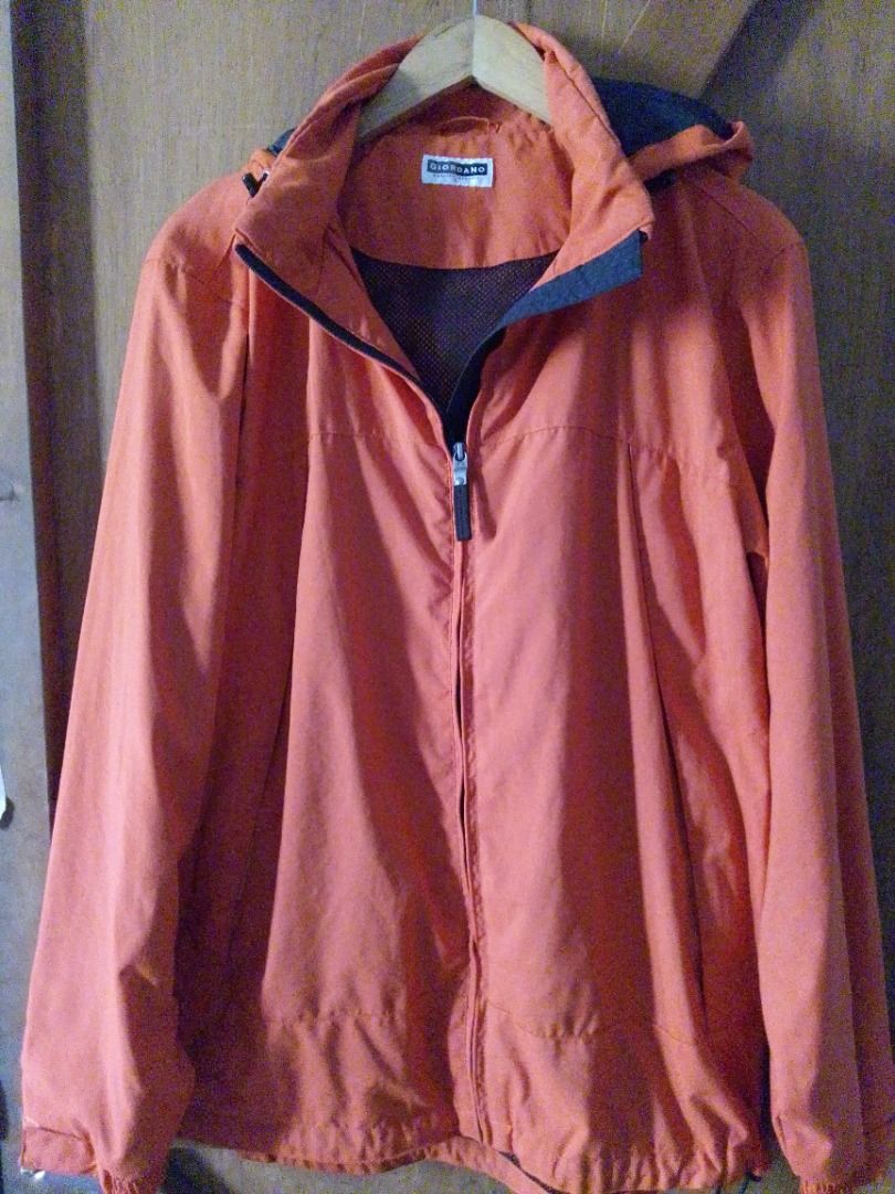 Giordano Orange Hooded Jacket Size L (Category: Coats, Jackets and Outerwear) located in Pavia. Submitted by ilawod_shop (Listing ID 1467414811, Image 1). Description: - Brand/Model: Giordano Orange Hooded Jacket - Size: Large - Color: Orange with blue inner hood lining - Material: Lightweight outerwear - Features: Built-in hood, full coverage, clean seam and neckline stitching - Condition: Good, perfect for casual everyday wear - W:21, L:28.