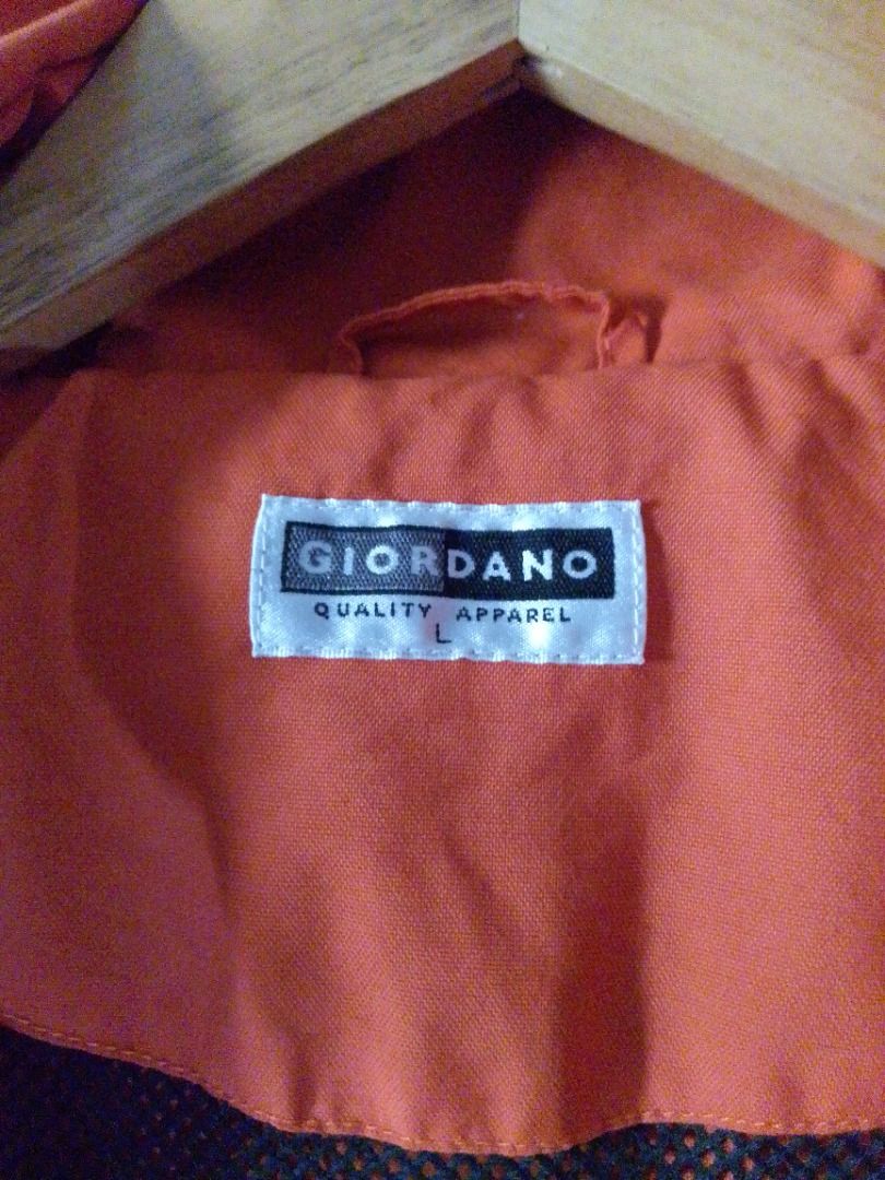 Giordano Orange Hooded Jacket Size L (Category: Coats, Jackets and Outerwear) located in Pavia. Submitted by ilawod_shop (Listing ID 1467414811, Image 3). Description: - Brand/Model: Giordano Orange Hooded Jacket - Size: Large - Color: Orange with blue inner hood lining - Material: Lightweight outerwear - Features: Built-in hood, full coverage, clean seam and neckline stitching - Condition: Good, perfect for casual everyday wear - W:21, L:28.