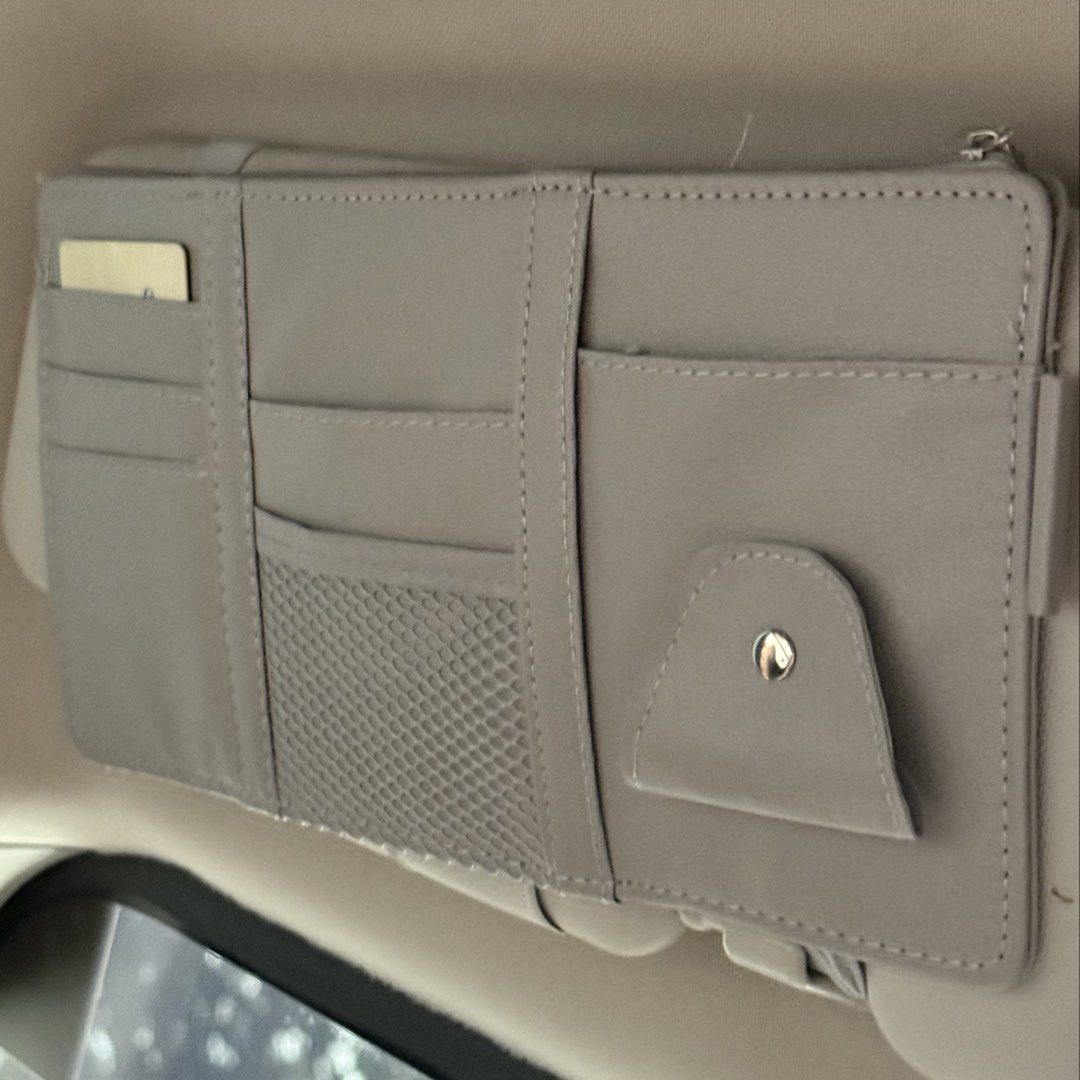 Grey Car Visor Organizer Pouch Storage Pocket Holder (Category: Accessory Holder, Box & Organizers) located in Marikina City. Submitted by lovegoeson (Listing ID 1467535588, Image 1). Description: - Grey multi-pocket car visor organizer - Multiple card slots, mesh pocket, zipped compartment, and snap-button pouch - Perfect for storing cards, sunglasses, receipts, and small items - Easy elastic strap mounting setup - Clean neutral color matches mo