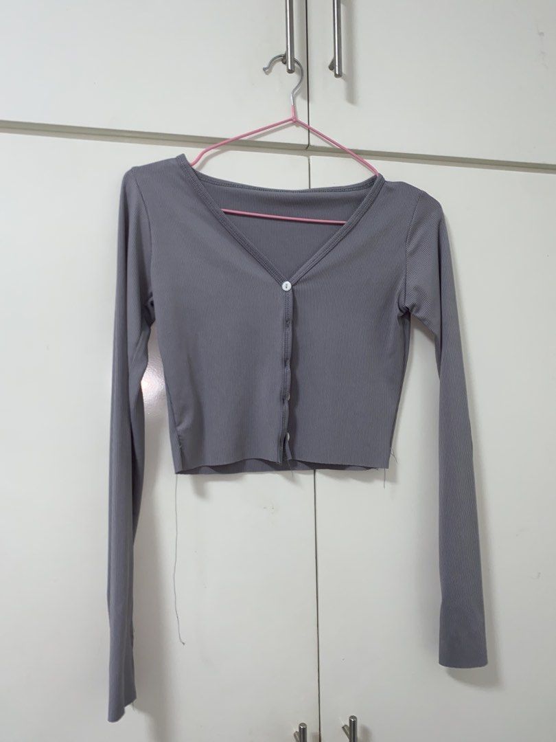 Grey Ribbed V-Neck Button-Up Crop Top Cardigan (Category: Longsleeves) located in Manila. Submitted by quickeagle.521fc7 (Listing ID 1467384872, Image 1). Description: Grey ribbed knit cardigan, long sleeves. V-neck cut with white front buttons. Cropped length, nice basic piece for layering. Light wear on the bottom hem stitching, still in decent shape overall. Soft stretchy material..