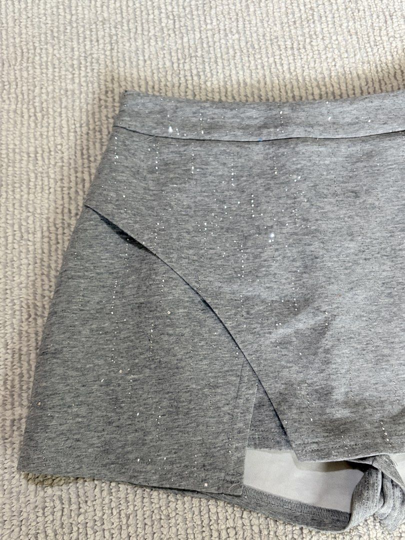 Grey Sparkly Wrap Skort (Category: Shorts) located in Daraga. Submitted by hiaqb (Listing ID 1467425717, Image 3). Description: - Color: Grey with subtle glitter specks - Design: Wrap-around front panel with a fitted waistband - Comfort: Built-in shorts underneath for full coverage - Material: Stretchy and comfortable fabric - Versatility: Easy to dress up or down for any occasion.