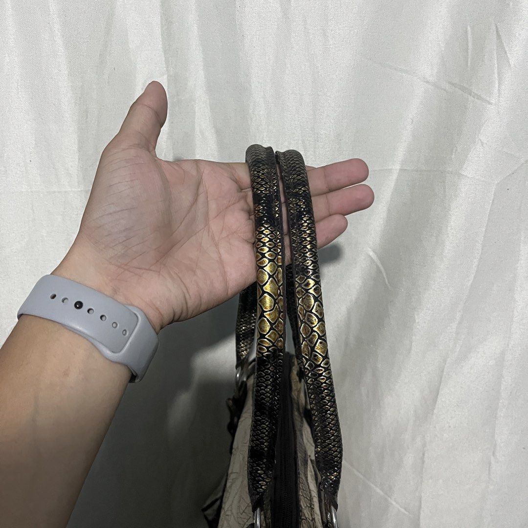 Guess beige and metallic snakeskin pattern handbag (Category: Luxury Bags & Wallets) located in Manila. Submitted by thrifted4life (Listing ID 1467536987, Image 2). Description: - Brand: Guess - Material: Cream embroidered monogram canvas with metallic gold-black snakeskin trim - Hardware: Silver-tone with branded zipper pull - Storage: Dual straps, structured bottom with metal feet, front zippered compartment, and front flap pocket - Perfect sta