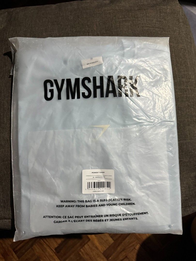 Gymshark Power T-Shirt Light Blue Medium (Category: Tshirts & Polo Shirts ) located in Las Pinas. Submitted by mojoejoejoe2 (Listing ID 1467377016, Image 2). Description: - Brand: Gymshark (Power t-shirt) - Color: Light blue - Size: Medium (tagged as oversized, fits like a Large) - Condition: Brand new, still sealed in original plastic packaging with barcode sticker - Features: Oversized fit, Gymshark branding across the back shoulders.