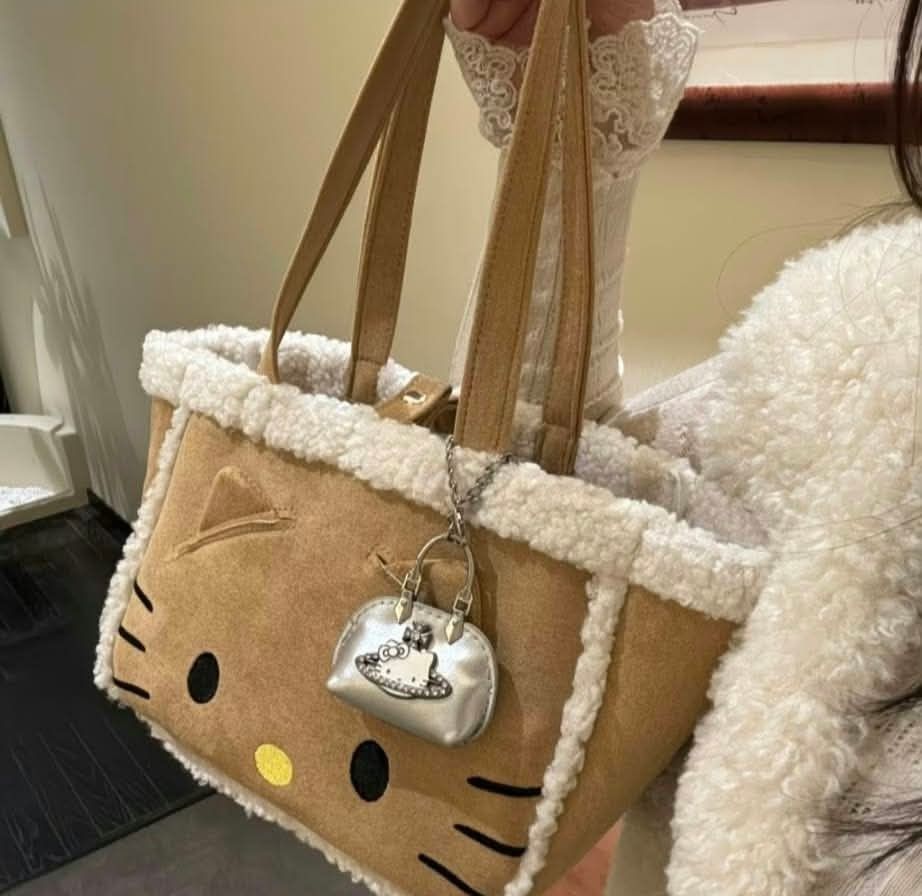 Hello Kitty Faux Shearling Tote Bag with Charm (Category: Tote Bags) located in Manila. Submitted by breansfinds (Listing ID 1467484704, Image 2). Description: COD NATIONWIDE - Adorable brown suede-like Kitty tote bag with fluffy white shearling trim - Features embroidered yellow nose and black whiskers on the front - Soft and cozy plush texture with a roomy interior for all your daily essentials - Comes with comfortable dual shoulder straps - In