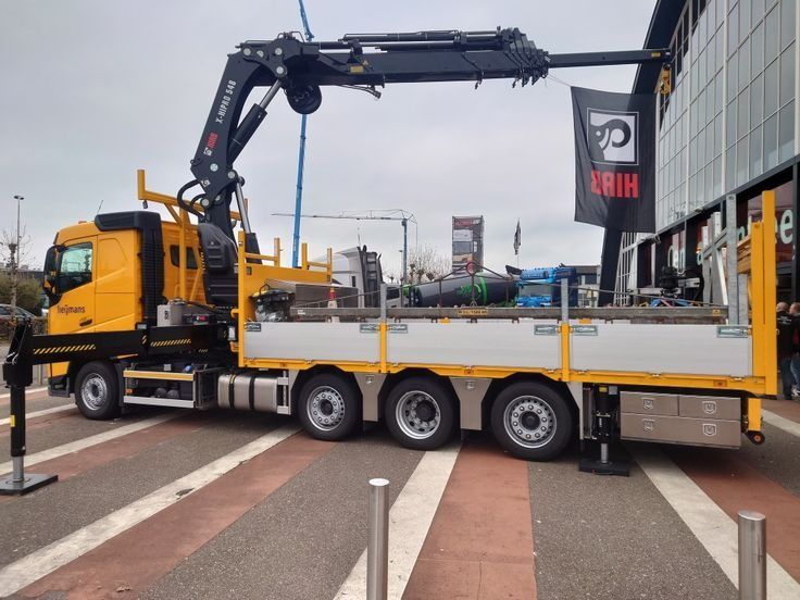 Hiab Crane Truck Yellow Cargo Flatbed (Category: Heavy Vehicles) located in Caloocan City. Submitted by xcmgmachinery (Listing ID 1467369778, Image 1). Description: Heavy-duty yellow truck equipped with a large Hiab crane arm. Flatbed cargo area ready for heavy lifting and transport. Outrigger stabilizers deployed on the side for safe operation. Multiple storage compartments underneath the flatbed. Powerful commercial vehicle for construction or 