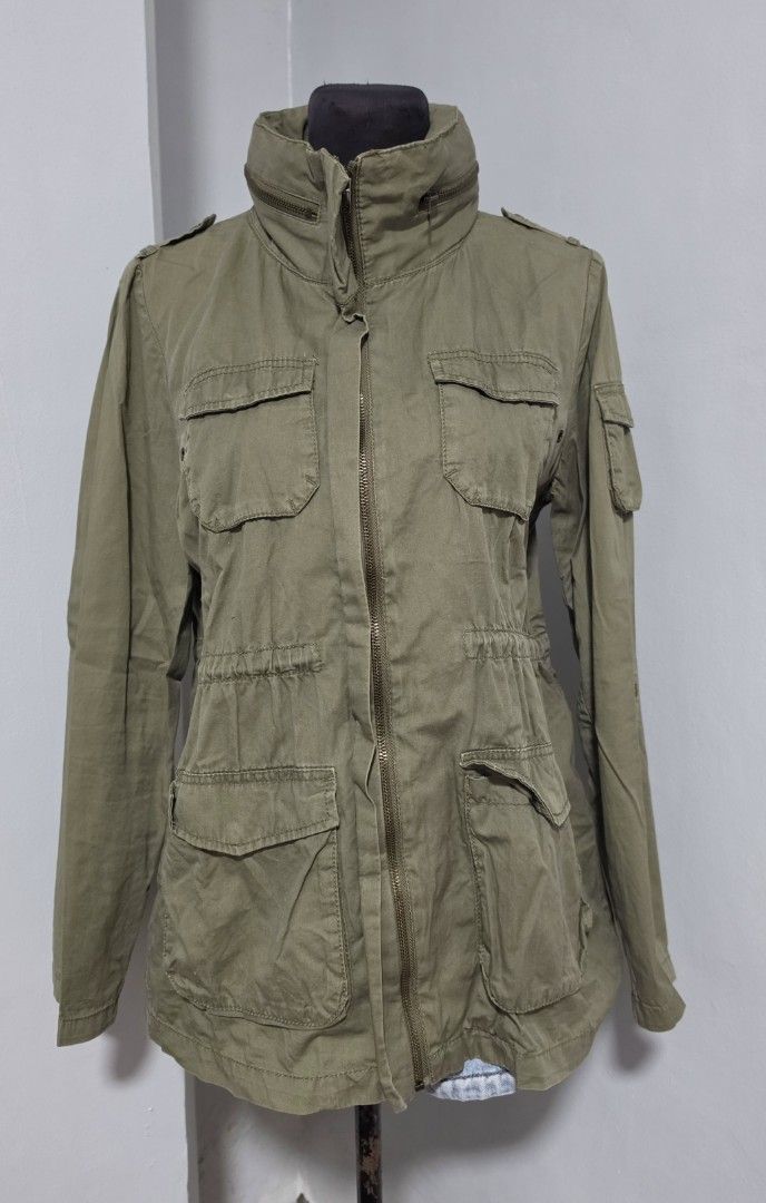 H&M Olive Green Utility Jacket Cargo Style with Pockets (Category: Coats, Jackets and Outerwear) located in Paranaque City. Submitted by franinnashop (Listing ID 1467390162, Image 1). Description: DECLUTTER MEDIUM PARANAQUE CITY - Color: Olive green - Style: Utility jacket with high collar and decorative zippers - Pockets: Multiple cargo pockets on chest and lower front - Fit: Adjustable drawstring waist for a fitted silhouette - Sleeves: Convert