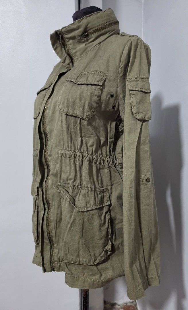 H&M Olive Green Utility Jacket Cargo Style with Pockets (Category: Coats, Jackets and Outerwear) located in Paranaque City. Submitted by franinnashop (Listing ID 1467390162, Image 3). Description: DECLUTTER MEDIUM PARANAQUE CITY - Color: Olive green - Style: Utility jacket with high collar and decorative zippers - Pockets: Multiple cargo pockets on chest and lower front - Fit: Adjustable drawstring waist for a fitted silhouette - Sleeves: Convert