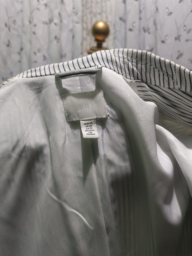 H&M Striped Double Breasted Blazer Size XS (Category: Coats, Jackets and Outerwear) located in Caloocan City. Submitted by _misskaye (Listing ID 1467470745, Image 2). Description: - Brand: H&M - Item: Striped double-breasted blazer - Color: White and blue - Size: XS - Details: Notched lapel collar, matching buttons, full lining - Condition: Clean inside and out - Style: Classic tailored fit, ideal for work or smart casual outfits.