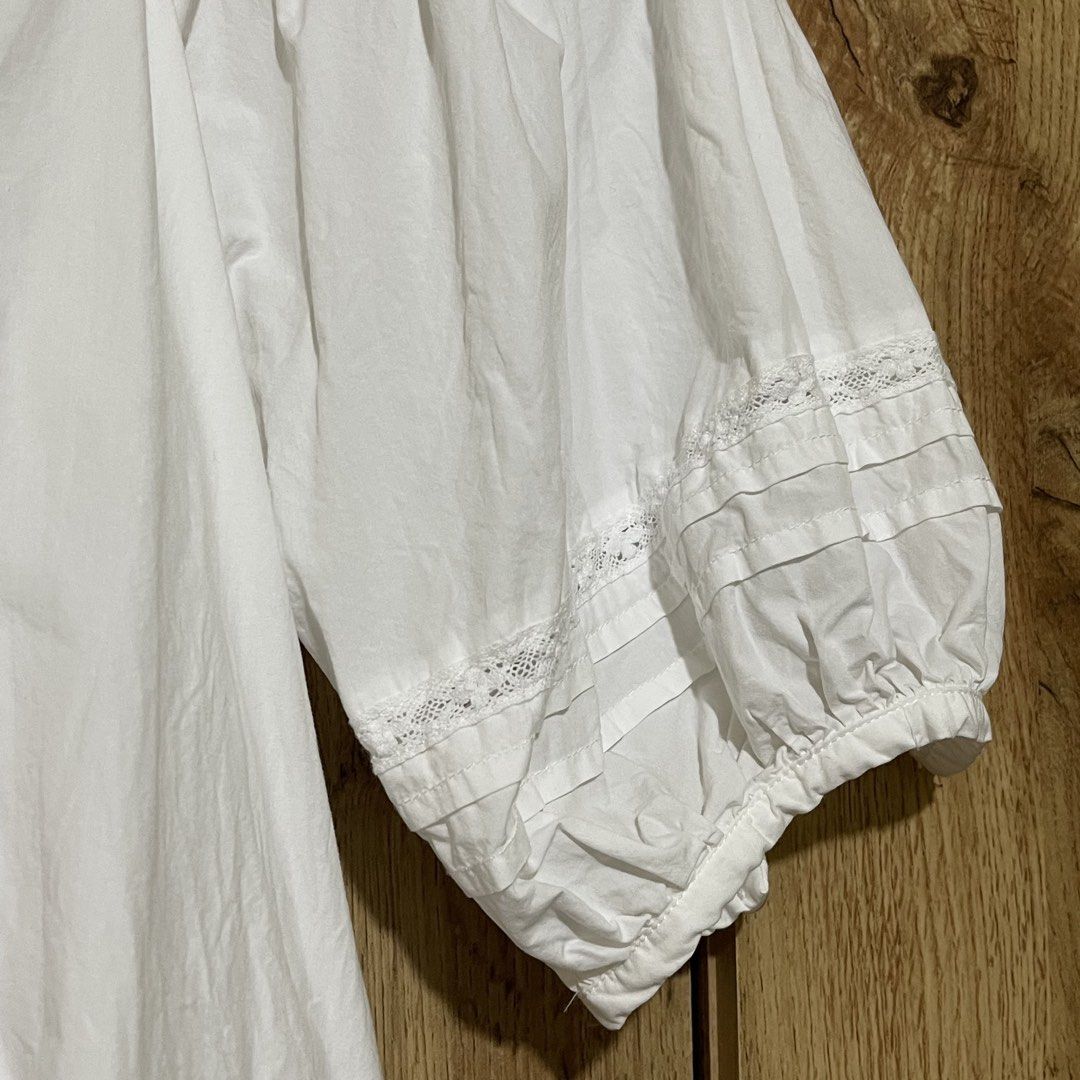 H&M White Square Neck Blouse Size S (Category: Blouses) located in Manila. Submitted by cluttercleanwme (Listing ID 1467581329, Image 3). Description: - Brand: H&M - Size: S - Color: White - Material: Lightweight and breathable cotton - Design: Square neckline with front pintuck pleats - Sleeves: Mid-length balloon sleeves with lace and pleated cuff details - Hem: Matching lace and pleated trim along the bottom - Styling: Versatile piece, great f