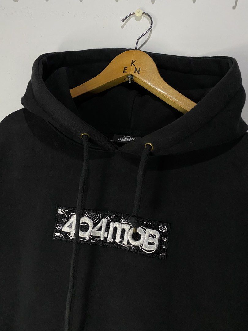 HODIE JACKET (Category: Hoodies) located in Jaen. Submitted by oshimamark58418 (Listing ID 1467455616, Image 2). Description: - Brand: 404MOB - Color: Black - Size: XL (Tagged L, manual measurement 24x28 inches) - Condition: 7/10 pre-owned, well-maintained - Features: Eye-catching white embroidered box logo with bandana/paisley pattern, adjustable drawstring hood, and front kangaroo pocket - Perfect for daily streetwear and casual wear.