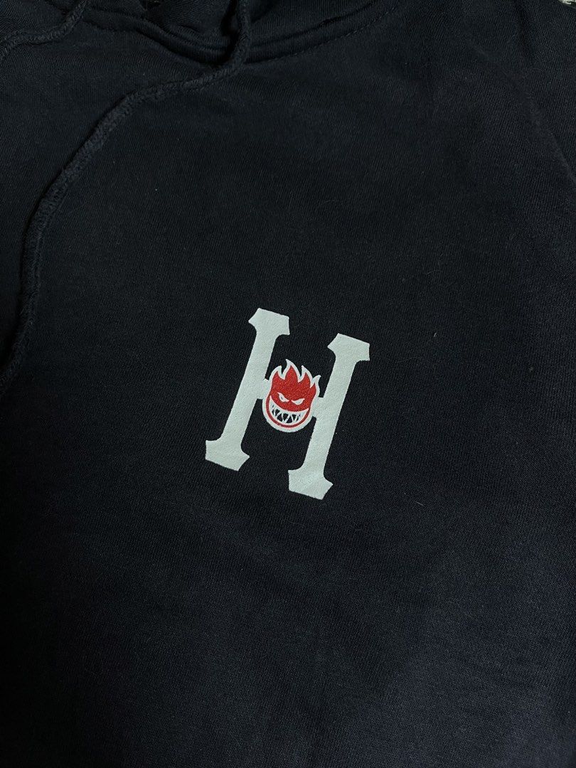 HUF x Spitfire Black Hoodie (Category: Hoodies) located in Silang. Submitted by yusthrift (Listing ID 1467391423, Image 2). Description: - Brand: HUF x Spitfire - Color: Black - Style: Pullover hoodie with drawstring and front kangaroo pocket - Graphics: Small chest print and large back print - Fit & Material: Standard fit, comfortable cotton blend - Condition: Pre-owned with normal signs of wear and slight cracking on the front graphic Size: L o