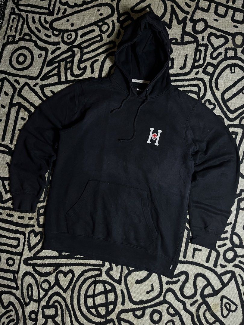 HUF x Spitfire Black Hoodie (Category: Hoodies) located in Silang. Submitted by yusthrift (Listing ID 1467391423, Image 1). Description: - Brand: HUF x Spitfire - Color: Black - Style: Pullover hoodie with drawstring and front kangaroo pocket - Graphics: Small chest print and large back print - Fit & Material: Standard fit, comfortable cotton blend - Condition: Pre-owned with normal signs of wear and slight cracking on the front graphic Size: L o