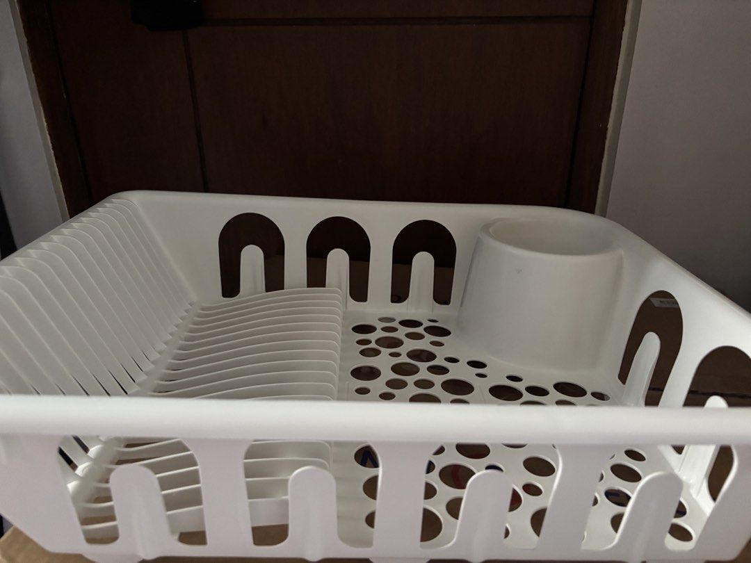 Ikea White Plastic Dish Drying Rack with Cutlery Holder (Category: Food Organization & Storage) located in Manila. Submitted by muhriak (Listing ID 1467414520, Image 2). Description: - Color: White - Material: Durable plastic, easy to wipe clean - Design: Vertical slots for plates and bowls - Drainage: Flat section with circular drainage holes for cups and small items - Convenience: Built-in corner utensil holder cup - Ideal for: Kitchen counter 