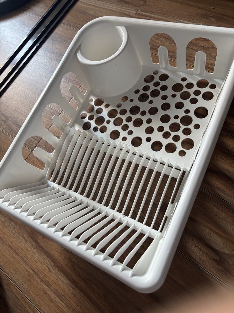 Ikea White Plastic Dish Drying Rack with Cutlery Holder (Category: Food Organization & Storage) located in Manila. Submitted by muhriak (Listing ID 1467414520, Image 1). Description: - Color: White - Material: Durable plastic, easy to wipe clean - Design: Vertical slots for plates and bowls - Drainage: Flat section with circular drainage holes for cups and small items - Convenience: Built-in corner utensil holder cup - Ideal for: Kitchen counter 