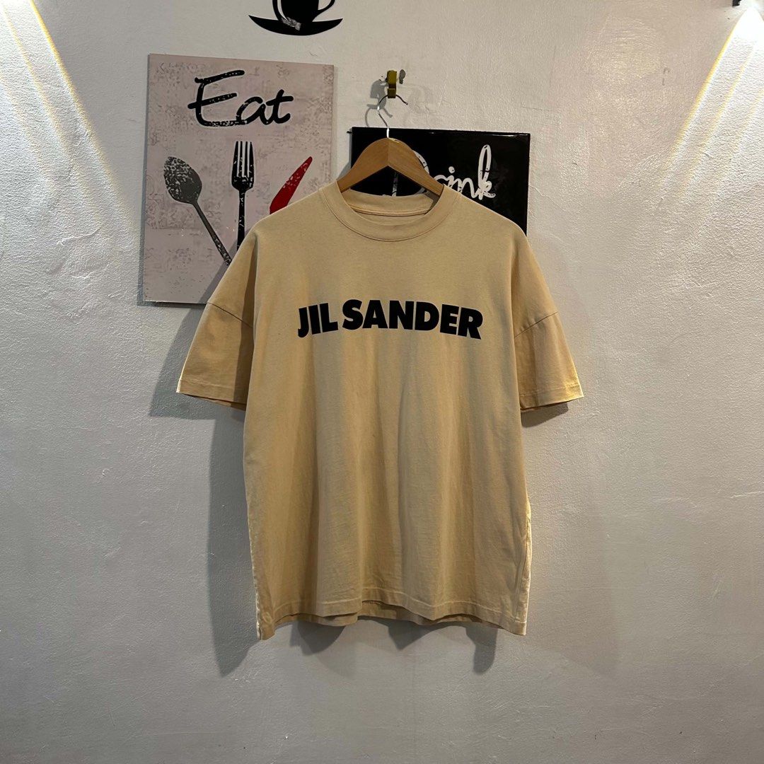 Jil Sander+ Beige Logo T-Shirt Size S (Category: Shirts) located in Manila. Submitted by jakes_thrift_shop (Listing ID 1467512432, Image 1). Description: - Jil Sander+ beige t-shirt - Size S tag attached - Features a bold black logo print on the chest - Classic crew neck and short sleeves - Comfortable relaxed fit - 100% premium cotton, made in Greece - Pristine condition with clean fabric and clear interior labels.