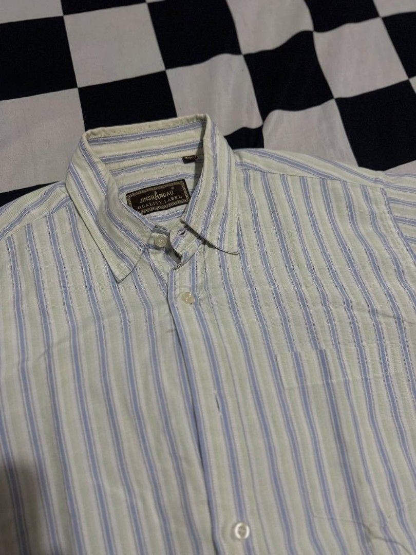 Jinshandao Short Sleeve Striped Button Down Shirt (Category: Tshirts & Polo Shirts ) located in Binan City. Submitted by kaiz3nnnn_ (Listing ID 1467478339, Image 2). Description: - Color/Pattern: Light yellow background with blue and green vertical stripes - Features: Collar neck, front button closure, and single left chest pocket - Fit & Fabric: Regular fit, lightweight material ideal for warm weather - Condition: Excellent pre-loved condition, 