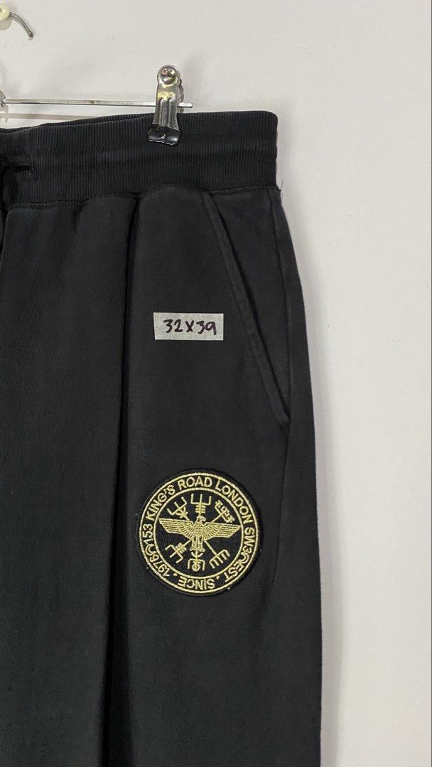 JOGGER PANTS (Category: Joggers) located in Jaen. Submitted by oshimamark58418 (Listing ID 1467409833, Image 3). Description: - Brand: Boy London - Style: Jogger Pants / Sweatpants - Color: Black with metallic gold prints - Size: 32 (Medium) - Features: Bold gold eagle & dreamcatcher graphic on leg, front badge logo, and 'BOY' embroidery on back pocket - Details: Elastic waistband with drawstring, rib-knit cuffs - Condition: Excellent pre-owned c