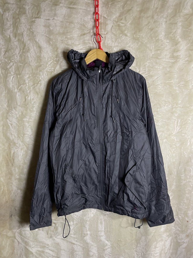 Jordan Jumpman Gray Hooded Windbreaker Jacket Size S (Category: Coats, Jackets and Outerwear) located in Molave. Submitted by charlesthrifter (Listing ID 1467366751, Image 1). Description: - Authentic Jordan windbreaker jacket in size Small - Stylish gray body with an embroidered purple Jumpman logo on the sleeve - Functional hood with a reflective strip down the back for visibility - Breathable printed mesh interior lining - Full zipper closure 