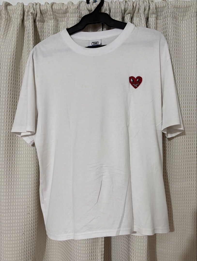 Keith Haring White Graphic T-Shirt (Category: Tshirts & Polo Shirts ) located in Makati City. Submitted by neelojosue75925 (Listing ID 1467373179, Image 1). Description: - White graphic tee by Trends Leader - Features a quirky embroidered heart patch on the chest - Large Keith Haring artwork printed on the back - Signature logo detail on the right sleeve - Casual crew neck fit made from soft, comfortable cotton - Versatile piece, easy to style wi