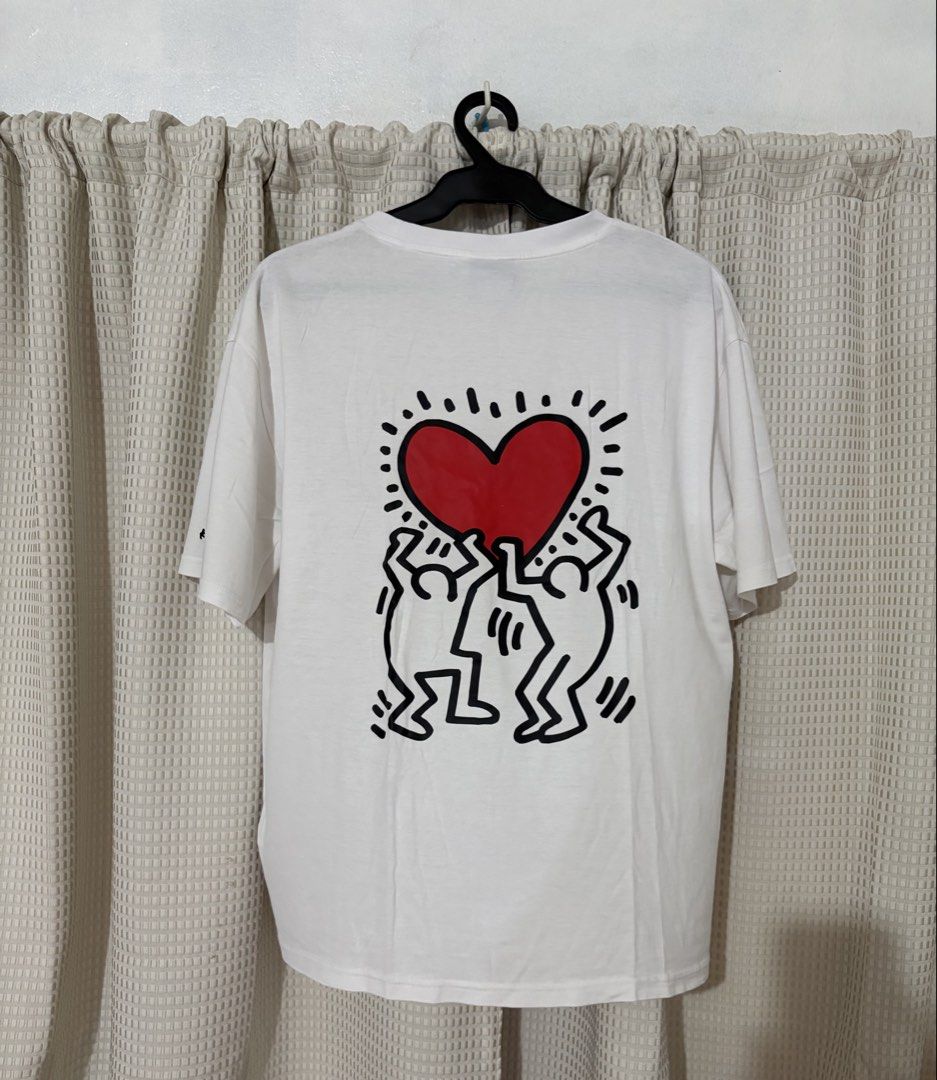 Keith Haring White Graphic T-Shirt (Category: Tshirts & Polo Shirts ) located in Makati City. Submitted by neelojosue75925 (Listing ID 1467373179, Image 2). Description: - White graphic tee by Trends Leader - Features a quirky embroidered heart patch on the chest - Large Keith Haring artwork printed on the back - Signature logo detail on the right sleeve - Casual crew neck fit made from soft, comfortable cotton - Versatile piece, easy to style wi