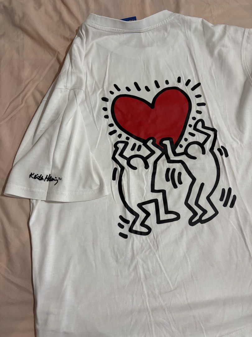 Keith Haring White Graphic T-Shirt (Category: Tshirts & Polo Shirts ) located in Makati City. Submitted by neelojosue75925 (Listing ID 1467373179, Image 3). Description: - White graphic tee by Trends Leader - Features a quirky embroidered heart patch on the chest - Large Keith Haring artwork printed on the back - Signature logo detail on the right sleeve - Casual crew neck fit made from soft, comfortable cotton - Versatile piece, easy to style wi