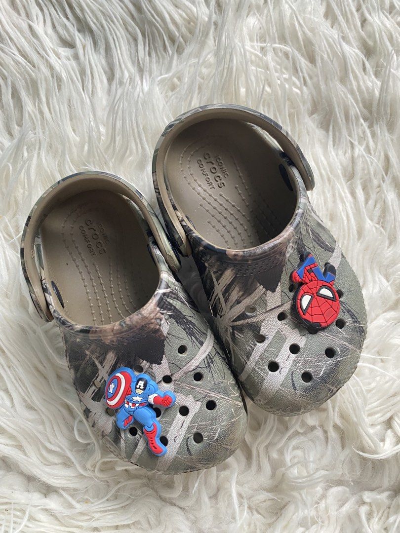 Kids Crocs Camo with Marvel Jibbitz Size C7 (Category: Babies & Kids Fashion) located in Tabaco. Submitted by camila_p (Listing ID 1467442979, Image 1). Description: - Kids Crocs in cool camo pattern - Size C7 molded on outsole, 11-13cm - Includes authentic Spider-Man and Captain America Jibbitz charms - Features Iconic Crocs Comfort cushioning - Easy slip-on style with pivoting heel straps.