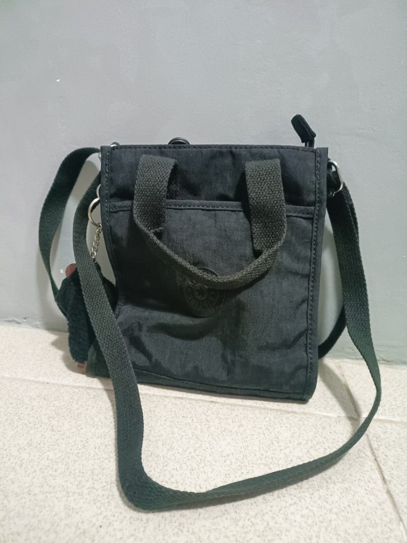 Kipling black crossbody bag with top handles (Category: Cross-body Bags) located in Taal. Submitted by zildreiven (Listing ID 1467392679, Image 1). Description: - Brand: Kipling - Color: Classic Black - Material: Durable crinkled nylon - Features: Dual top handles and adjustable/detachable shoulder strap - Compartments: Secure zip-top closure, light grey interior lining, internal zip pocket, and open slip pockets - Exterior: Front zip pocket with