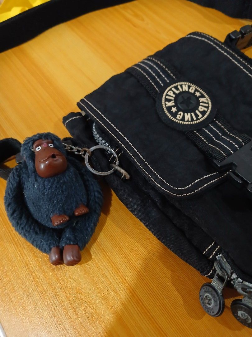 Kipling Black Crossbody Bag with Monkey Keychain (Category: Cross-body Bags) located in Daraga. Submitted by thethriftcity2024 (Listing ID 1467407648, Image 2). Description: - Authentic black Kipling crossbody bag in clean, well-kept condition - Durable crinkle nylon material featuring stylish white contrast stitching - Secure front flap closure with plastic buckle and classic round logo patch - Includes the signature furry dark grey monkey keych