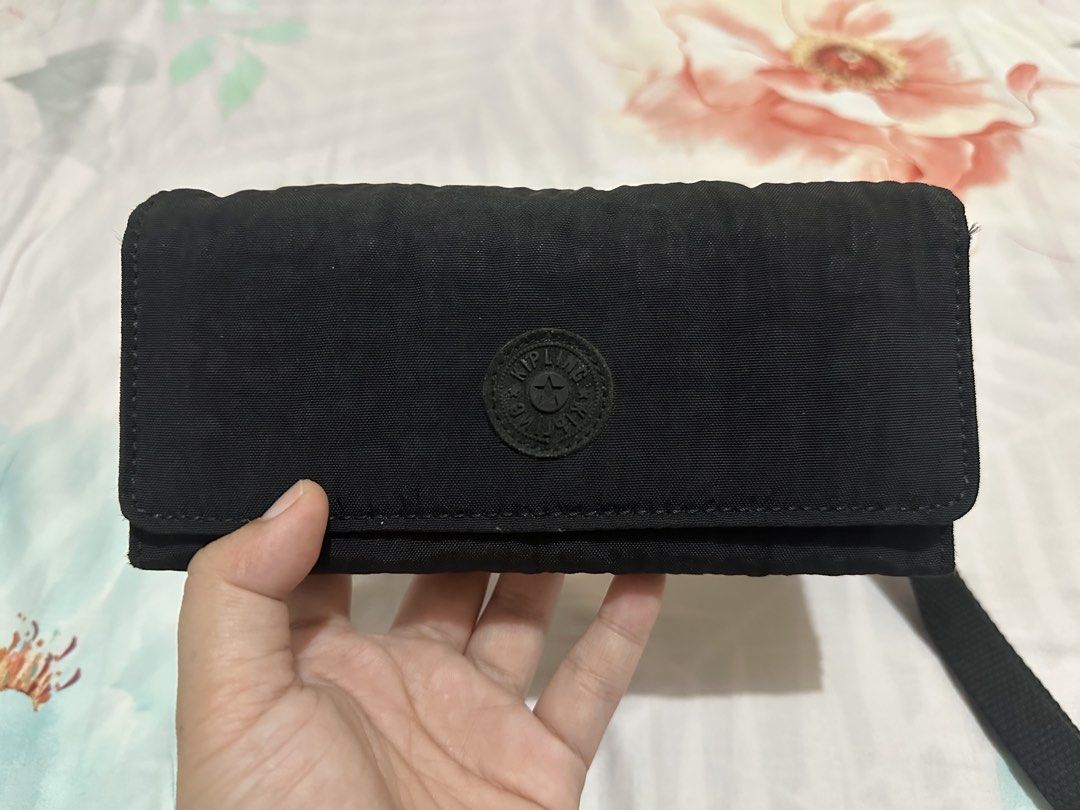 Kipling Black Long Wallet with Wrist Strap and Monkey Keychain (Category: Wallets & Card holders) located in Quezon City. Submitted by crjnsmr (Listing ID 1467474882, Image 2). Description: Color: Classic Black Material: Signature crinkled nylon Closure: Secure front snap flap Interior: Multiple card slots, ID window, cash compartments, and a zippered coin pouch Extras: Detachable wrist strap and iconic black fuzzy monkey keychain.