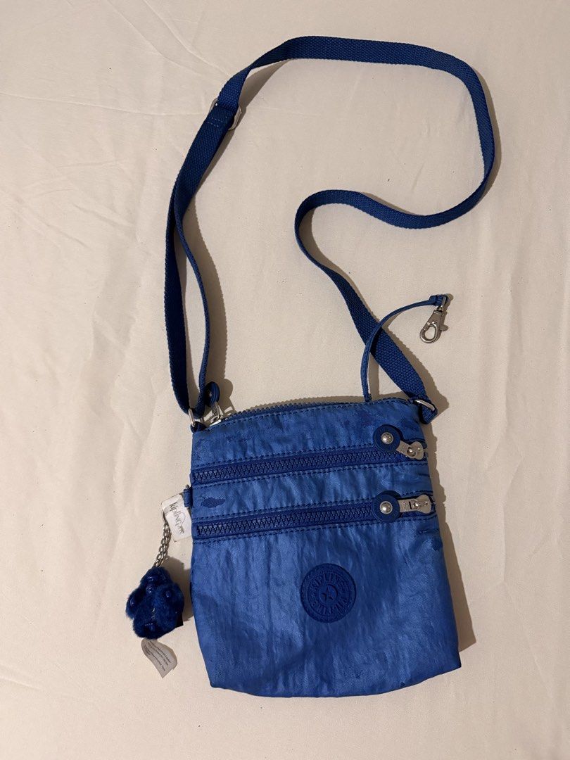 Kipling Blue Crossbody Bag with Monkey Keychain (Category: Cross-body Bags) located in Quezon City. Submitted by mynameismio (Listing ID 1467478141, Image 1). Description: - Brand: Kipling - Color: blue - Material: Signature crinkled nylon fabric with silver-tone hardware - Storage: Main zip compartment and two front zipper pockets - Strap: Adjustable shoulder strap for a custom fit - Inclusion: Matching blue monkey keychain on a metal chain - Co