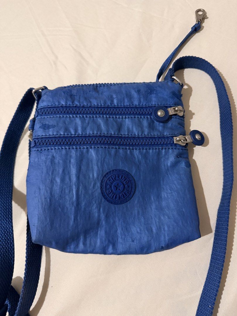Kipling Blue Crossbody Bag with Monkey Keychain (Category: Cross-body Bags) located in Quezon City. Submitted by mynameismio (Listing ID 1467478141, Image 2). Description: - Brand: Kipling - Color: blue - Material: Signature crinkled nylon fabric with silver-tone hardware - Storage: Main zip compartment and two front zipper pockets - Strap: Adjustable shoulder strap for a custom fit - Inclusion: Matching blue monkey keychain on a metal chain - Co
