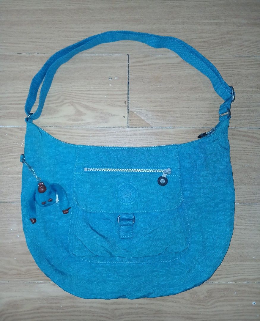Kipling K15023 Blue Shoulder Bag Hobo (Category: Shoulder Bags) located in Daraga. Submitted by thethriftcity2024 (Listing ID 1467407756, Image 1). Description: - Brand/Model: Authentic Kipling shoulder bag, Model K15023-584 - Color: Vibrant bright blue with matching fuzzy monkey keychain - Design: Front zip pocket, secure flap closure, and adjustable strap - Interior: Clean fabric lining with multiple inner compartments for organization - Condit