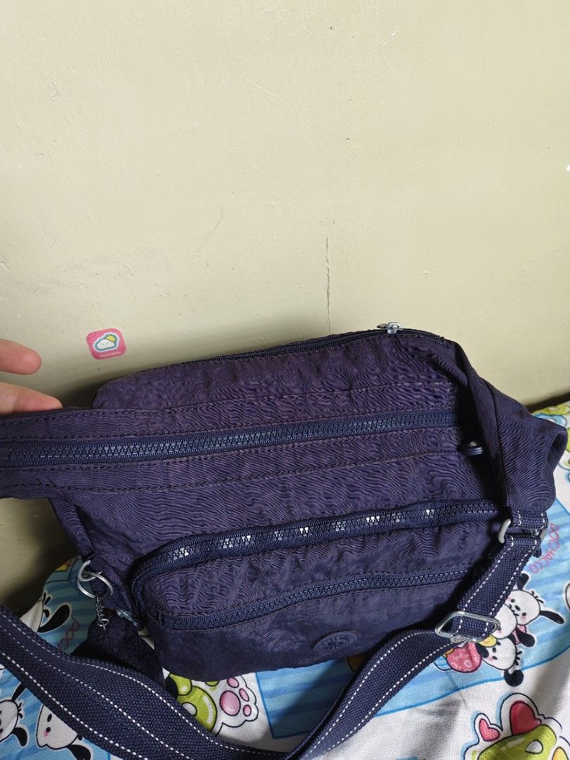 Kipling Purple Shoulder Bag with Monkey Keychain (Category: Shoulder Bags) located in General Mariano Alvarez. Submitted by findsandmoreph (Listing ID 1467367041, Image 3). Description: - Brand: Kipling - Color: Dark Purple - Material: Signature crinkled nylon - Pockets: Multiple front zip compartments - Strap: Adjustable for shoulder or crossbody wear - Inclusion: Original furry monkey keychain - Interior: Stylish patterned fabric lining - Condi
